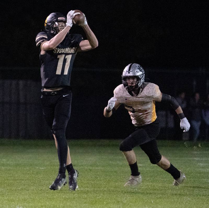Sycamore's Burke Gautcher (11) catches a pass against Kaneland’s Aric Johnson (23) during a football game at Kaneland High School in Maple Park on Friday, Sep 30, 2022.