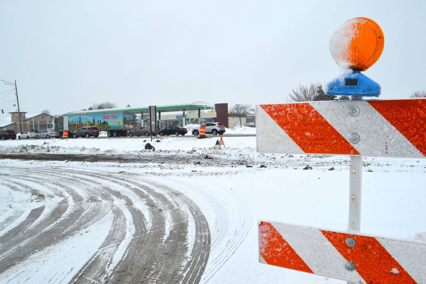 Traffic drives along a construction site on Weber Road in Romeoville as snow falls on Thursday, Feb. 4, 2021. The National Weather Service calls for more snow and low temperatures throughout the weekend.