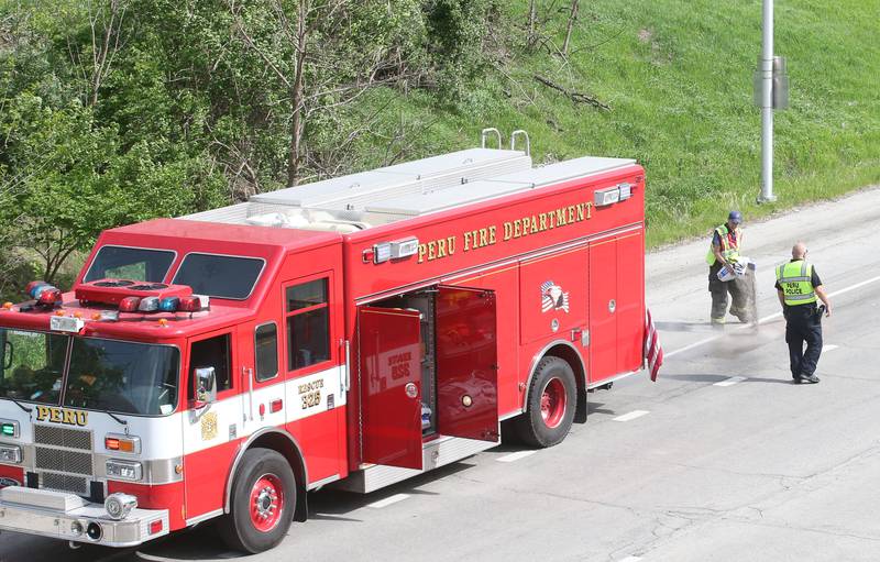 Peru firefighters work the scene of a tractor and tandem disk that leaked hydraulic fluid on the shoulder of Illinois Route 251 and 7th Street overpass on Monday, April 28, 2025. Peru Fire, Illinois Department of Transportation and Peru police responded to the incident.