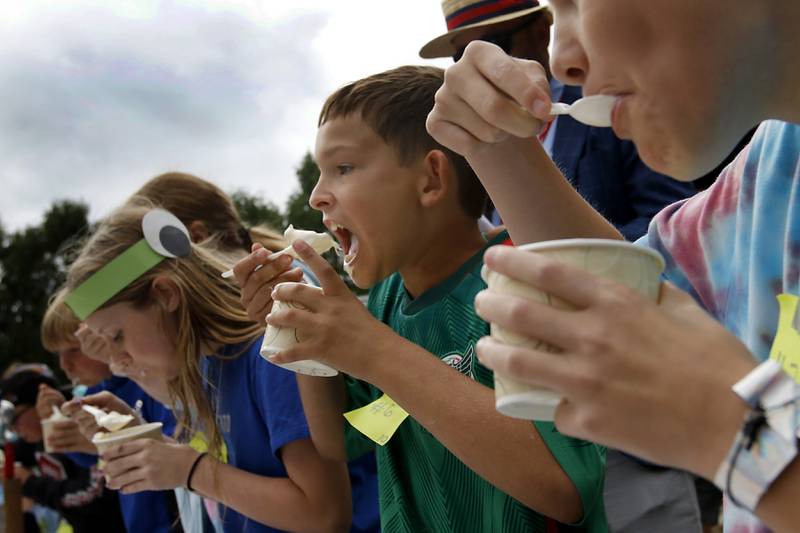 Luke Ridley (center) shovels ice cream into his mouth on his way to winning his round of the Brain Freese Ice Cream Eatin’ Contest during the Ice Cream Fest on Friday, Aug. 9, 2024, at Crystal Lake’s Main Beach.  The second annual event featured music, ice cream venders and the ice cream eating contest.