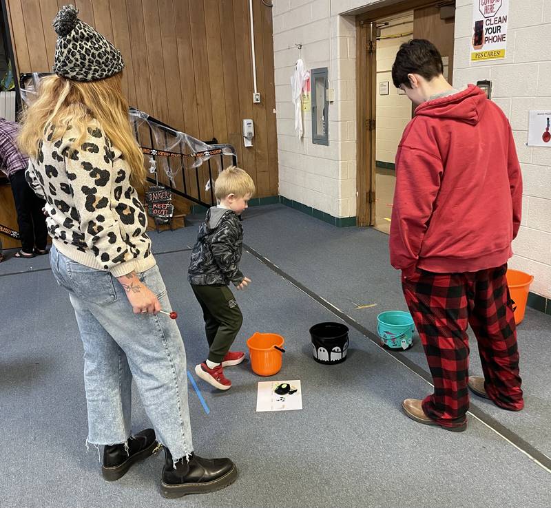 BEST high school students oversaw fall themed carnival games Thursday, Oct. 24, 2024, for the younger students. The BMP Tri-County Special Education Cooperative helped make this day possible. Playing the bucket game is Levi Gruber as BEST paraprofessional Courtney Engel and high school student Adam Stanmar look on.