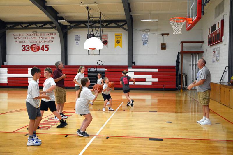 Kevin Hildebrand (left), girls basketball coach for LaMoille Grade School, and Pat Cinotte (right), coach for the Illinois Valley Warriors, run a shooting drill during Thursday's final session of the LaMoille High School basketball camp.