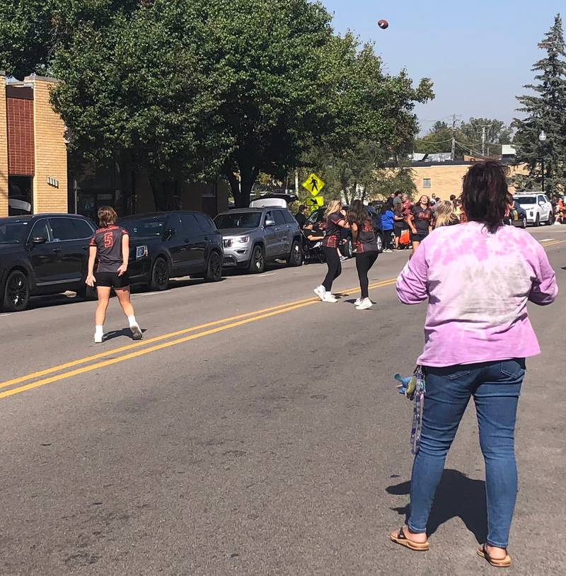Members of the McHenry High School flag football team throw a football at the McHenry High School Homecoming parade Oct. 6, 2024.