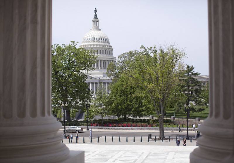 The U.S. Capitol building is seen May 5 through the columns on the steps of the Supreme Court in Washington. The House is poised to act on a bill that would temporarily patch over a multibillion-dollar pothole in federal highway and transit programs while ducking the issue of how to put the programs on sound financial footing for the long term.