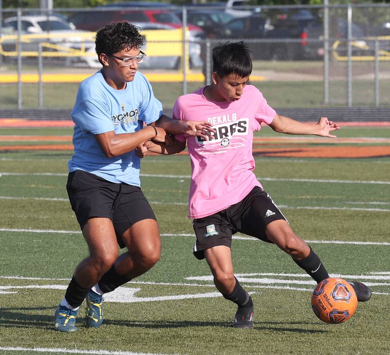 A DeKalb player kicks the ball by a Sycamore player Monday, July 14, 2025, during a summer boys soccer friendly at DeKalb High School.