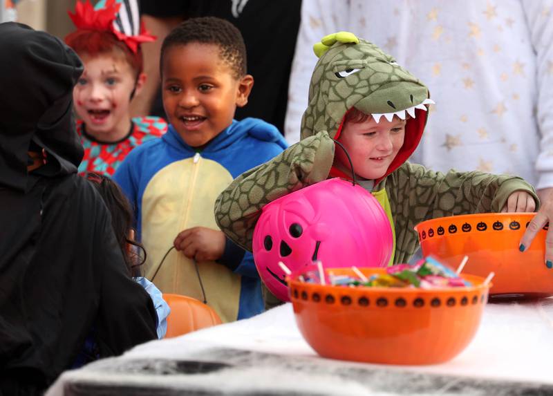 Luke Judkinis, 4, from DeKalb, gets a treat from one of the stops during the DeKalb Chamber of Commerce’s annual Spooktacular Tuesday, Oct. 29, 2024, in downtown DeKalb.