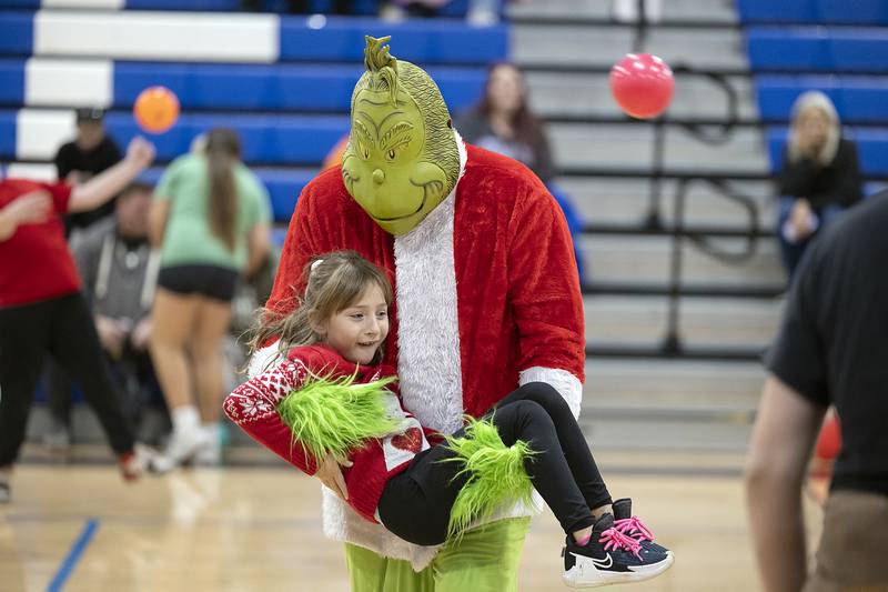 A Cindy Lou Who doppelgänger is scooped up by Grinch Saturday, Nov. 23, 2024, during the dodgeball fun.