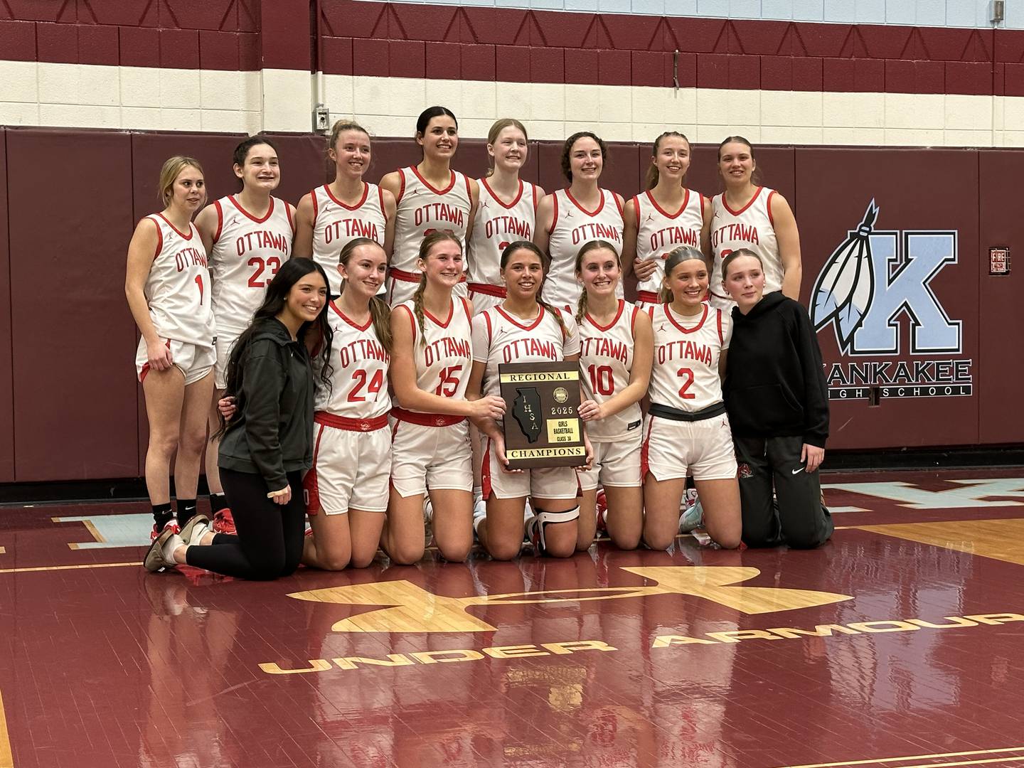 The Ottawa girls basketball team poses with the IHSA Class 3A Kankakee Regional championship plaque after defeating Kankakee 36-33 in overtime Thursday, Feb. 20, 2025.