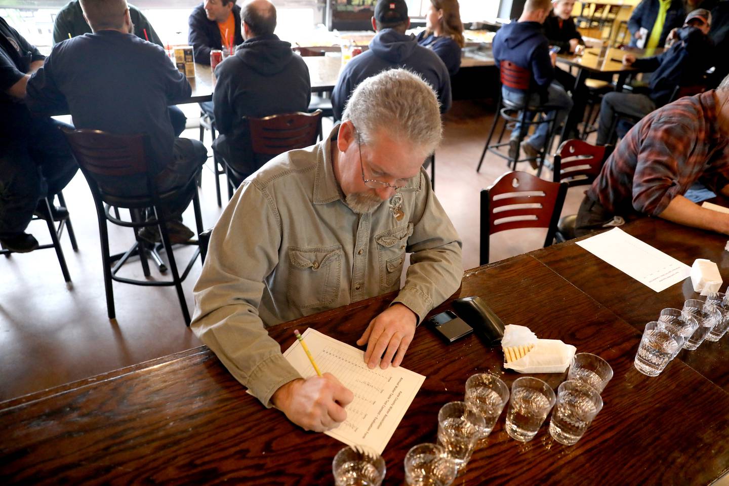 Trent Huber, retired from the City of Aurora, tastes water from various villages and cities throughout Kane County during the annual Kane County Water Association Water Taste Test at Global Brew in St. Charles on Thursday, Dec. 15, 2022.