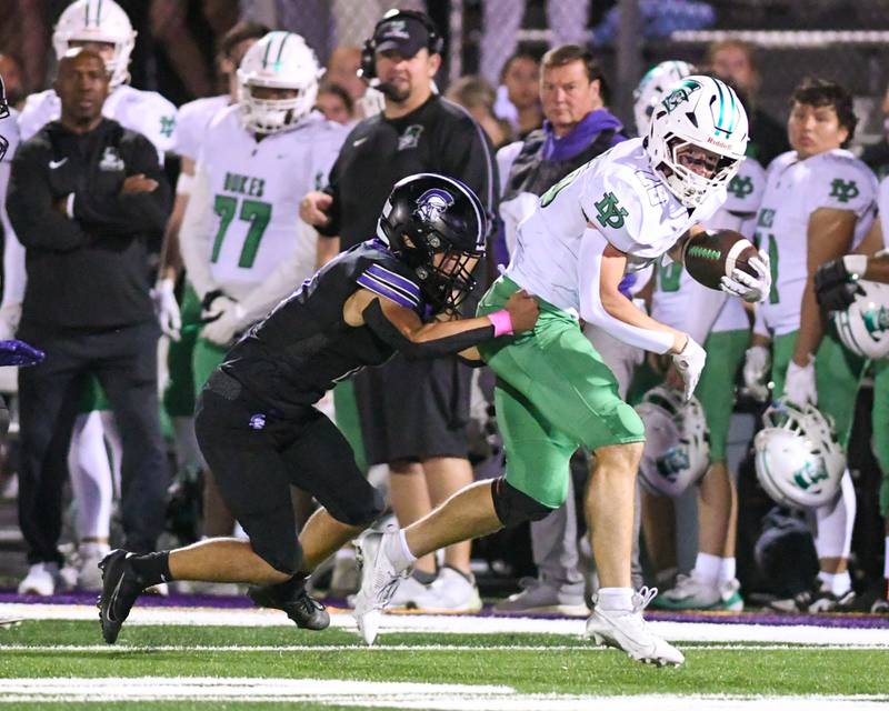 Downers Grove North's Caden Chiarelli, left, brings down Downers Grove North's Owen Noonan (26) during the game on Friday Oct. 10, 2025, held at Downers Grove North High School.