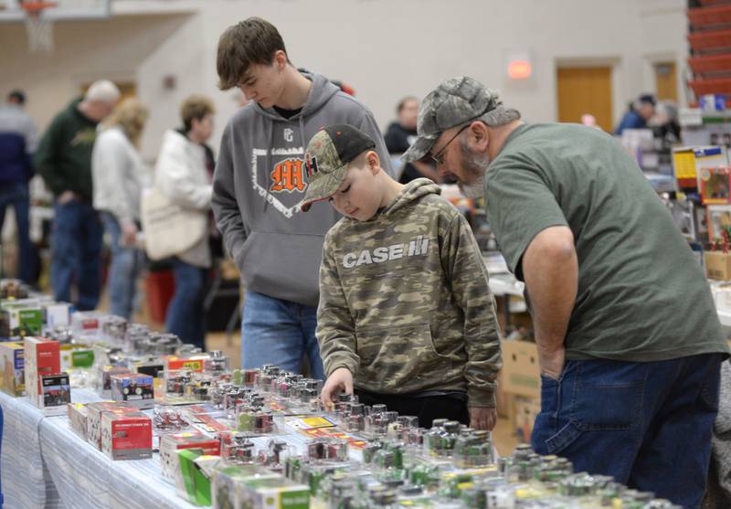Mike Wiersema, Jase Meiers, and Bryson Wiersema, all of Chadwick, peruse items for sale at the Forreston FFA Alumni's Farm Toy and Craft Show on Saturday, March 8, 2025 at the Forreston High School.