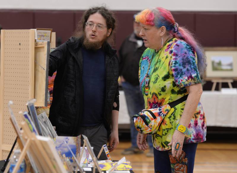 Artist Patrick Durkin (left) of Hinsdale discusses the art work of Sandra Ragan of Riverside while they attend the Art Show held at the Westmont Community Center Sunday March 19, 2023.