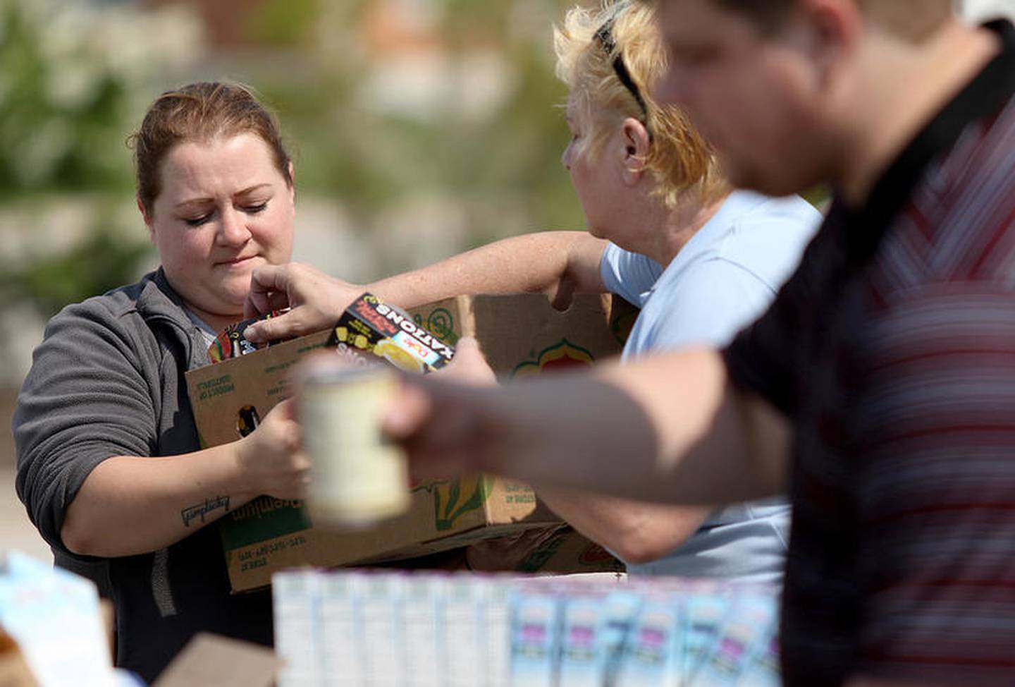 The late Cindy Graves (back right), Director of Community Health and Prevention at the DeKalb County Health Department helps fill a box of food for Allie McWilliams of DeKalb (left) at the Northern Illinois Food Bank's truck during a Healthy Start to School event at DeKalb County Health Department on Thursday, Aug. 3, 2017 in DeKalb. Graves died May 22, 2022 at Kishwaukee Hospital in DeKalb.