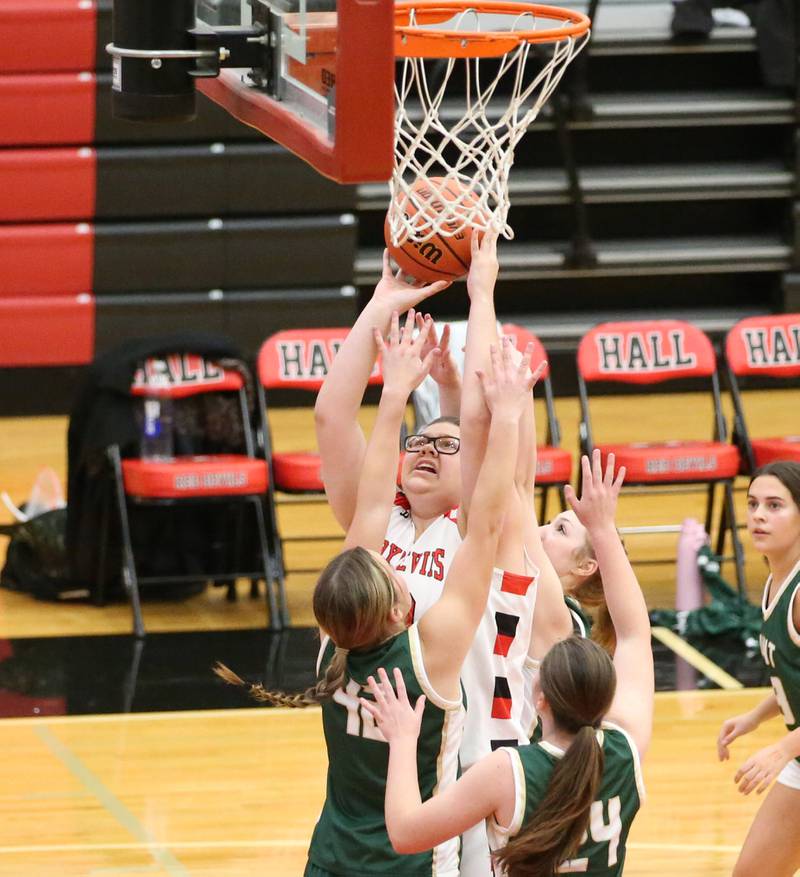 Hall's Toni Newton (32) scores on a shot underneath the hoop as St. Bede's Ella Hermes (42) and teammate Marly Tillman (24) defend on Monday, Nov. 28, 2022 at Hall High School in Spring Valley.