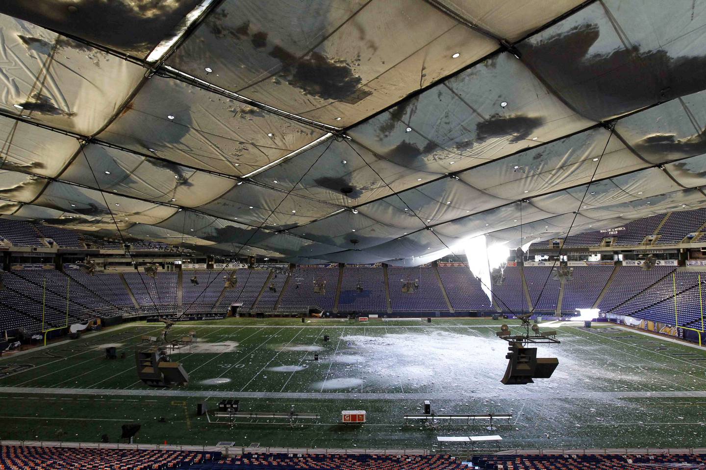 In this Dec. 12, 2010, file photo, snow falls into the field from a hole in the collapsed roof of the Metrodome in Minneapolis.