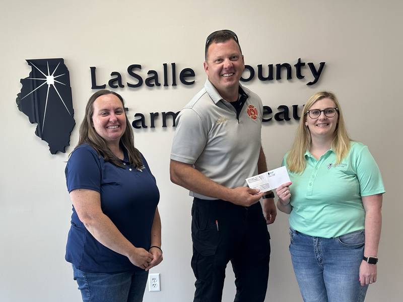 Members of the La Salle County Farm Bureau present a $1,000 donation to Ottawa Fire Chief Brian Bressner to support the purchase of grain bin rescue equipment for MABAS 25.