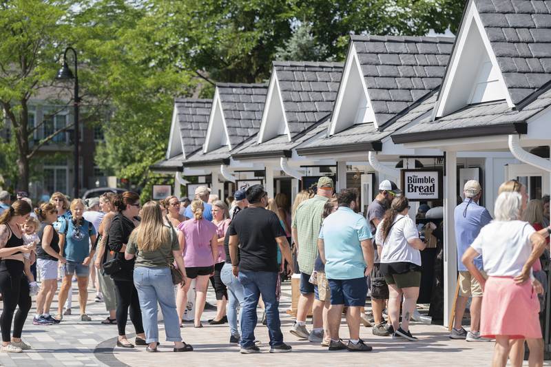 Shoppers explore the new collection of tiny shops at the grand opening and ribbon cutting of the new McHenry Riverwalk Shoppes in downtown McHenry on Friday, July 21, 2023. Ryan Rayburn for Shaw Local