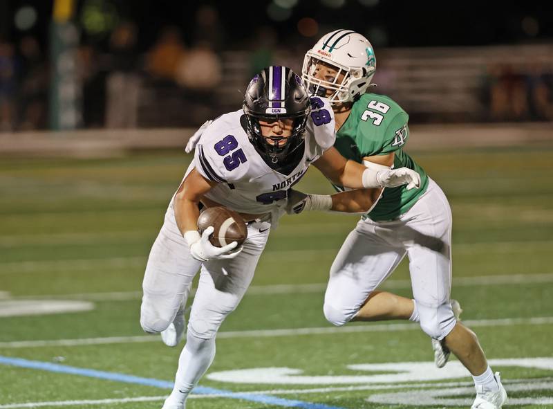 Downers Grove North's Will Vala (85) tries to break free from York's Owen Chael (36) during the varsity football game between Downers Grove North and York on Friday, Oct. 4, 2024 in Elmhurst.