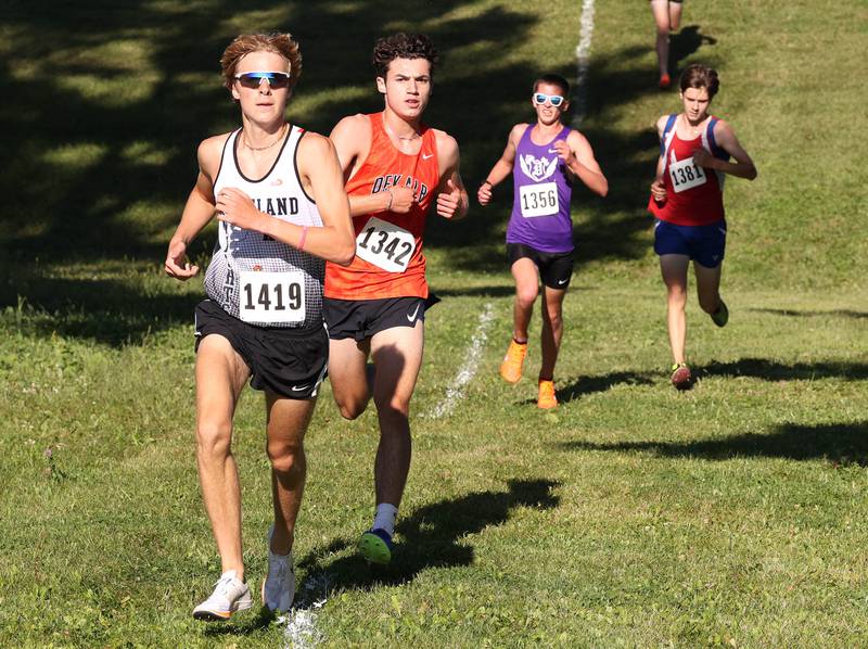 Kaneland’s Evan Nosek (left) and DeKalb’s  Jacob Barraza (second from left) make their way down a hill in September 2024, during the Sycamore Cross Country Invite at Kishwaukee College in Malta.