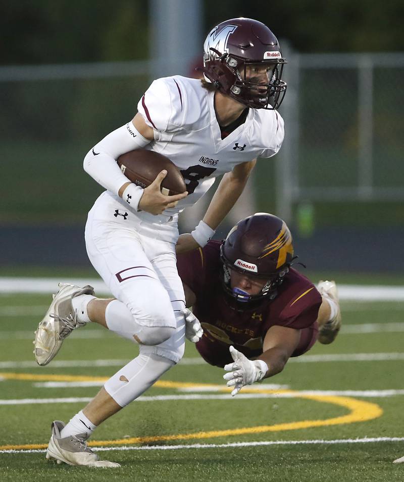Marengo's Joshua Holst runs with the ball as Richmond-Burton’s Toby Quentrall-Quezada tries to make a diving tackle during a Kishwaukee River Conference football game Friday, Sept. 9, 2022, between Richmond-Burton and Marengo at Richmond-Burton Community High School.