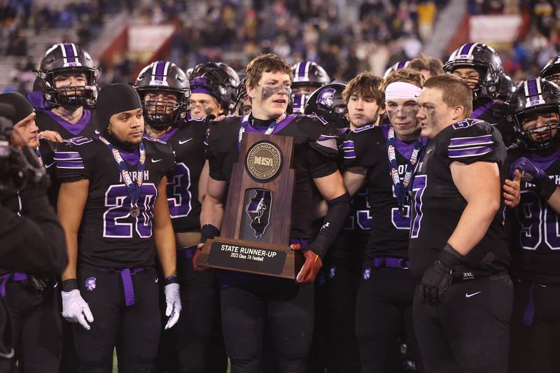 Downers Grove North’s captains receive the runner-up trophy after their 35-10 loss to Mt. Carmel in the Class 7A championship on Saturday, Nov. 25, 2023 at Hancock Stadium in Normal.