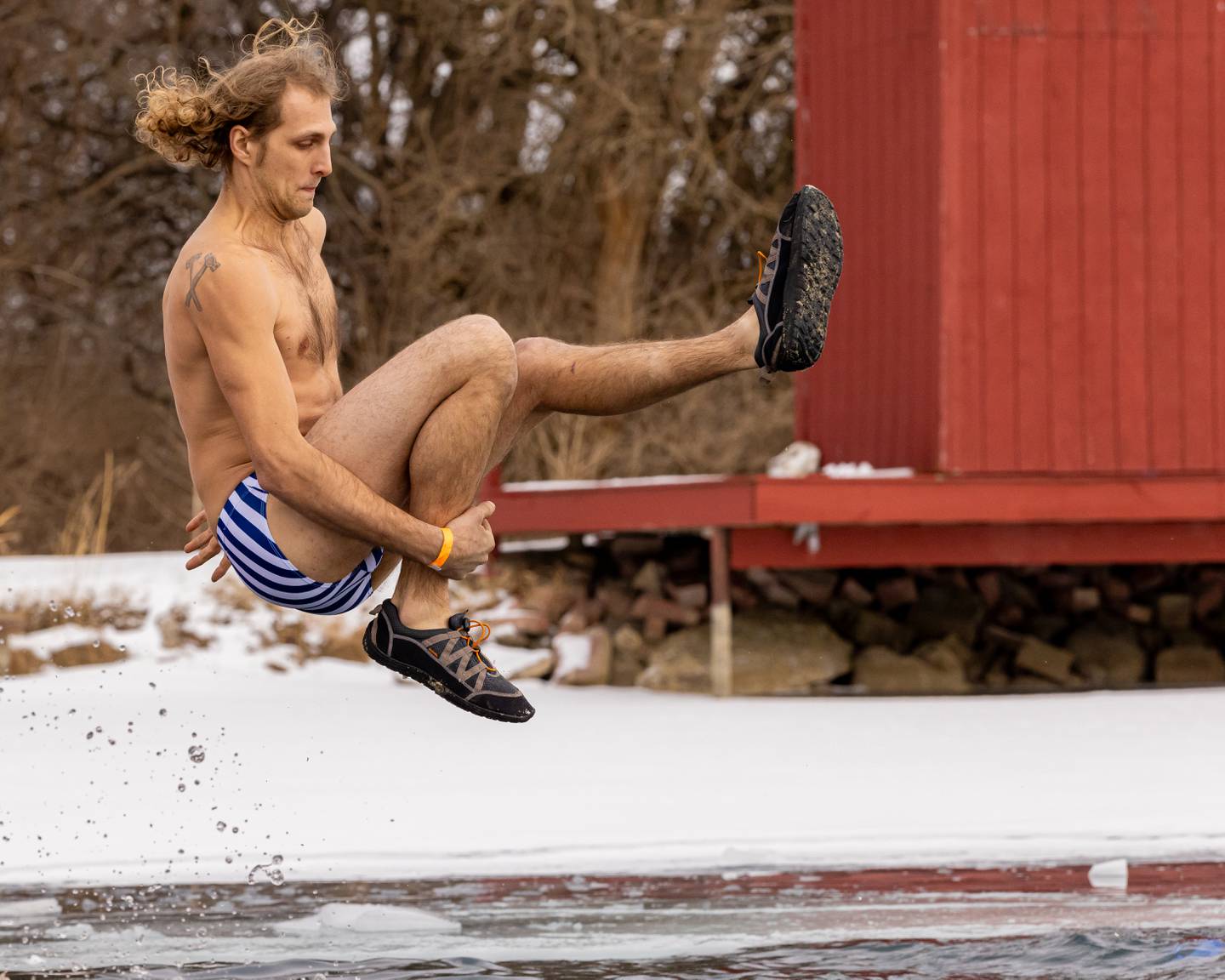 Alex Karpati of the Vactor plunging team does a can opener trick jump off of the dock at the Make-A-Wish Illinois Penguin Plunge on  January 31, 2026 at Skydive Chicago.