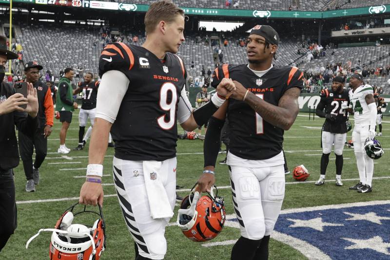 Cincinnati Bengals quarterback Joe Burrow (9) fist bumps wide receiver Ja'Marr Chase (1) after an NFL football game against the New York Jets Sunday, Sept. 25, 2022, in East Rutherford, N.J. The Bengals won 27-12. (AP Photo/Adam Hunger)