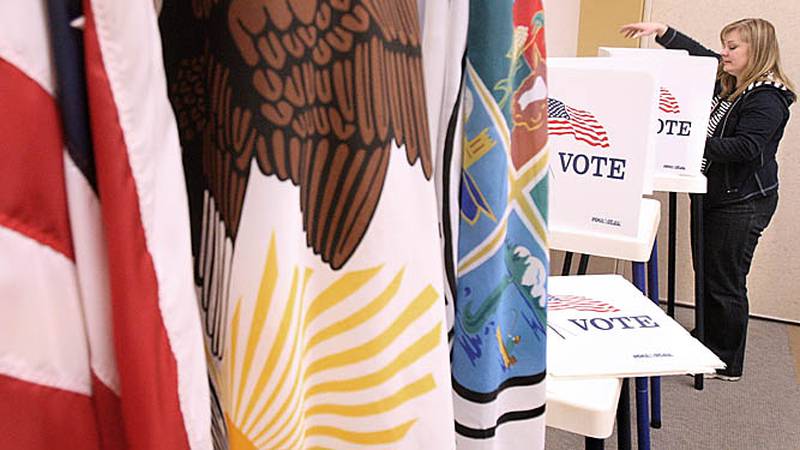 Julie Nollkamper, a deputy clerk at the DeKalb county elections office, sets up booths for early voting in the Legislative Center at 200 N. Main street in Sycamore on Friday.