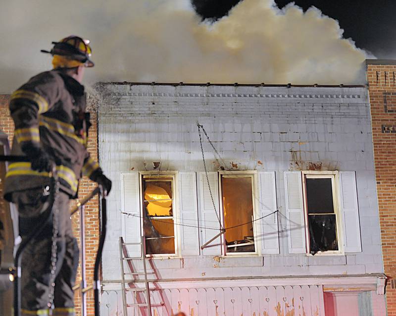 Firefighters battle flames above apartment outside Skoogs Pub & Grill on Sunday, May 10, 2015 downtown Utica.