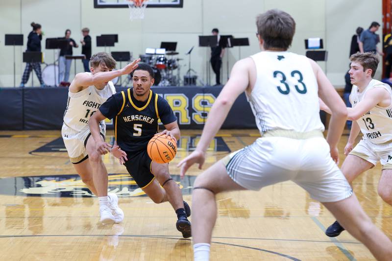 Herscher's Alek Draper drives against Bishop McNamara's Coen Demack during the Tigers' 71-42 loss to Bishop McNamara in the IHSA Class 2A Herscher Regional semifinal on Wednesday, Feb. 25, 2026.