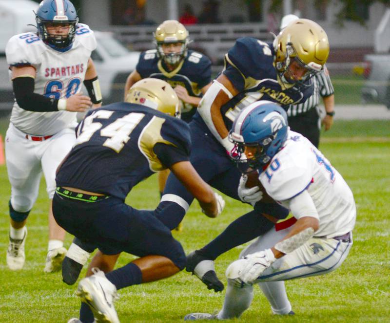 Polo's Estaban Salinas (54) and Jordan Reed (14) tackle a Bushnell-Prairie City player on Friday, Aug, 29, 2025 in 8-man action in Polo.