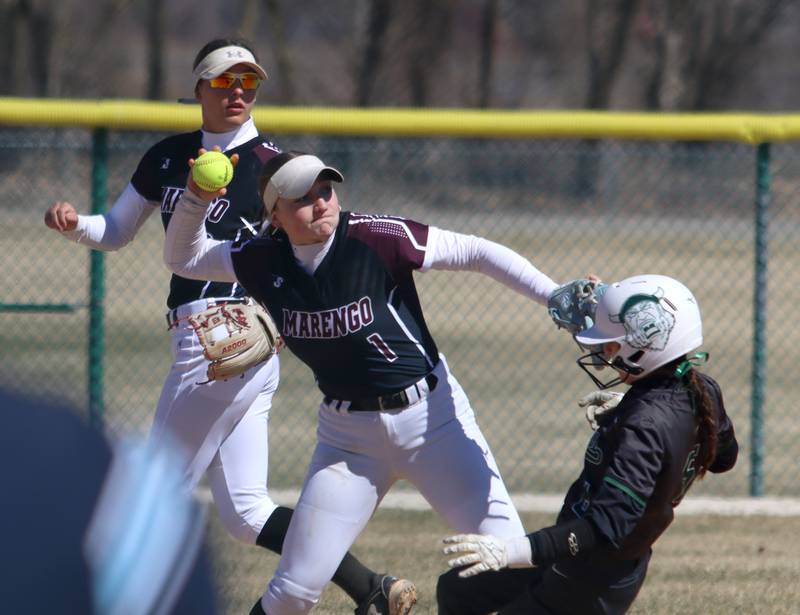 Marengo’s Gabrielle Gieseke, upper left, looks on as teammate Gabby Christopher forces a North Boone baserunner at second base in varsity softball at Marengo High School in Marengo on Saturday, March 22, 2025.