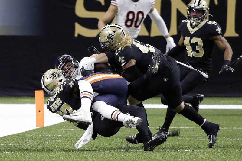 Chicago Bears tight end Cole Kmet is tackled on a reception by New Orleans Saints strong safety Malcolm Jenkins (27) and middle linebacker Alex Anzalone in the first half of an NFL wild-card playoff football game in New Orleans, Sunday, Jan. 10, 2021. (AP Photo/Butch Dill)