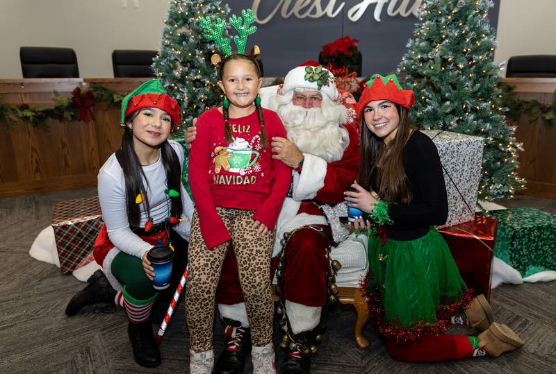 Crest Hill resident Gianna Alvarez takes a photo with Santa and his elves (Pilar Gonzales and Kate Richardson) during Winterfest at Crest Hill City Center on Nov. 30, 2024.