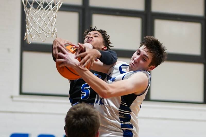 Hinckley-Big Rock's Alex Casanas (5) and Newark’s Payton Wills (15) fight for rebound during a basketball game at Newark High School on Tuesday, January 28, 2025.