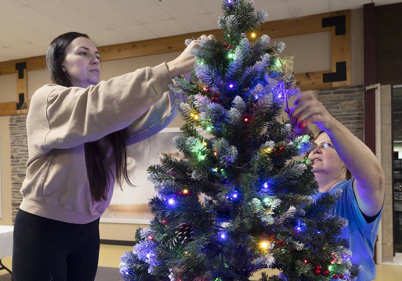 Megan Stinson (left) and mom Laura Ross put the touches on a tree decorated in dedication to family members Sunday, Nov. 17, 2024, for the Festival of Trees fundraiser.