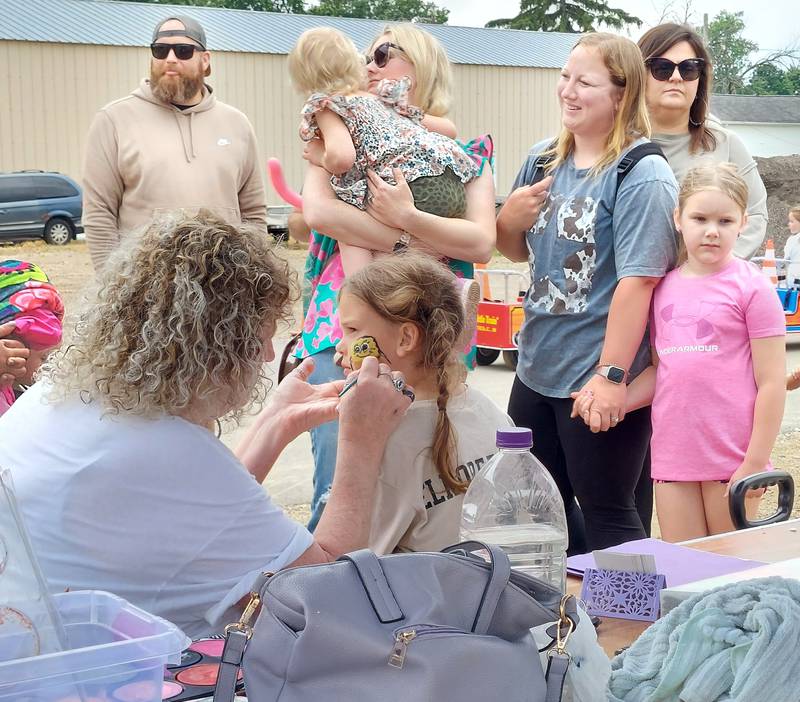 Evelyn Laethem, of Princeton, has SpongeBob Squarepants painted on her cheek Saturday, June 1, 2024, during the ShrimpFest and Brew Hullabaloo at Rotary Park in Princeton.
