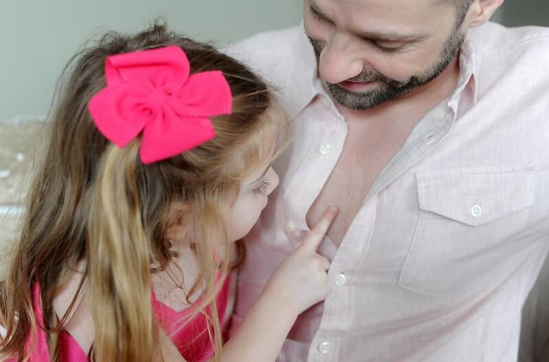 Everly Backe, 4, who has had multiple open heart surgeries to correct congenital heart defects, plays doctor Friday, Feb. 11, 2022, with her father, Matt Backe, in their Crystal Lake home. As Everly has became more aware of her chest scar, which they call her "zipper," her dad, Matt, recently decided to get a tattoo that matches his daughter’s scar from her surgeries so she does not feel alone in having the scar.