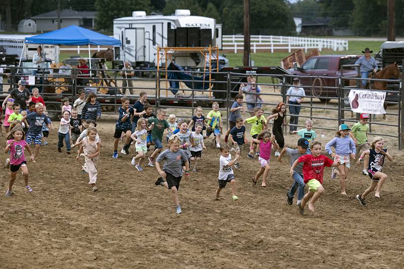 After removing their shoes, kids race to the far end of the rodeo ring to retrieve them Wednesday, Aug. 14, 2024, at the Whiteside County Fair in Morrison.