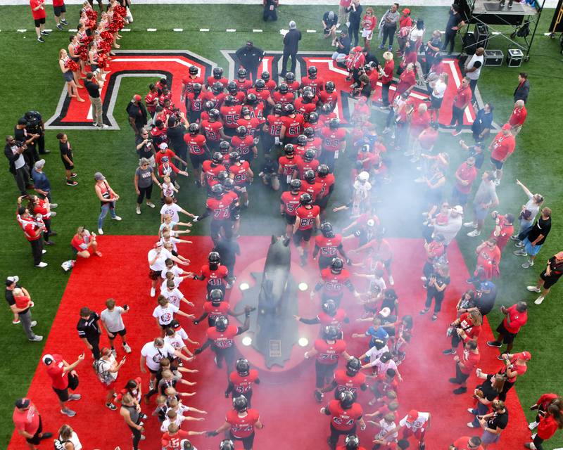 Northern Illinois University's football players give high five to young fans as they come out the lock room onto the field for the start of the game on Saturday Aug. 30, 2025, as they took on Holy Cross held at Huskie Stadium in DeKalb.