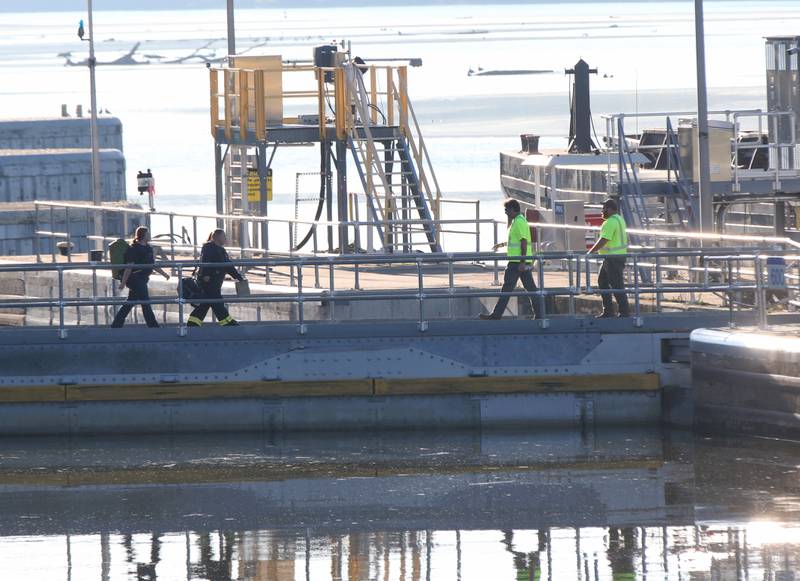 EMS crews and Starved Rock Lock and Dam workers walk across the locks to help on the scene of a fire inside the Starved Rock hydroelectric power plant at the Starved Rock Lock and Dam on Tuesday, Oct. 3, 2023 near Utica. A MABAS box alarm was sent out just before 730a.m. for a working fire inside the plant.