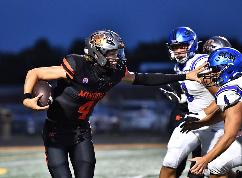 Minooka's Zane Caves (4) stiff arms St. Charles North's Wyatt Brandt (4) during the non-conference game on Friday, Aug. 29, 2025, at Minooka.