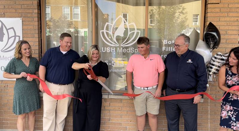 Caption: Surrounded by family, city and Chamber officials, LUSH MedSpa owner Lisa Johnson cuts the ceremonial ribbon during her Grundy County Chamber ribbon cutting in September.