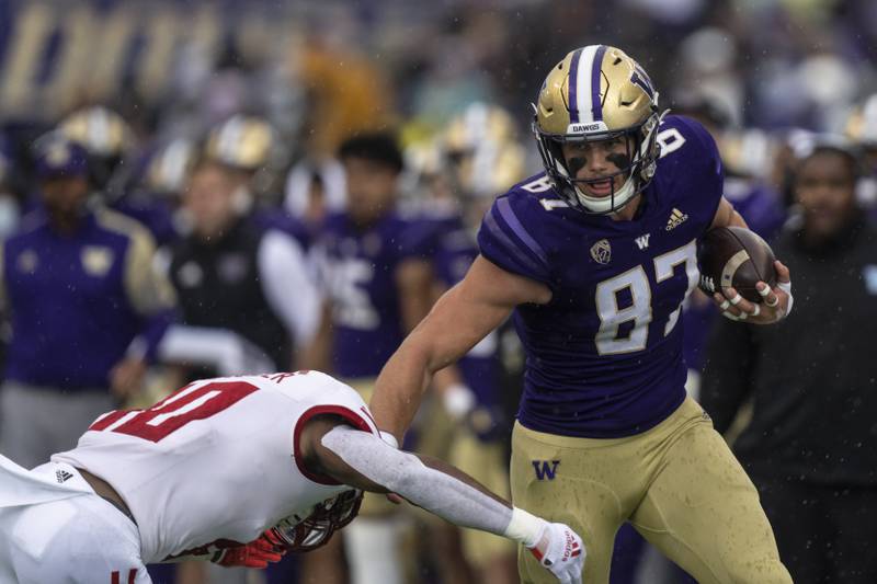 Washington tight end Cade Otton runs with the ball after a reception as Arkansas State defensive back Elery Alexander attempts to make a tackle on Sept. 18, 2021, in Seattle.