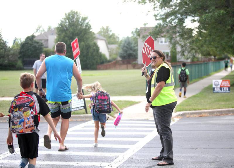 Administrators, police officers take on role of crossing guards at