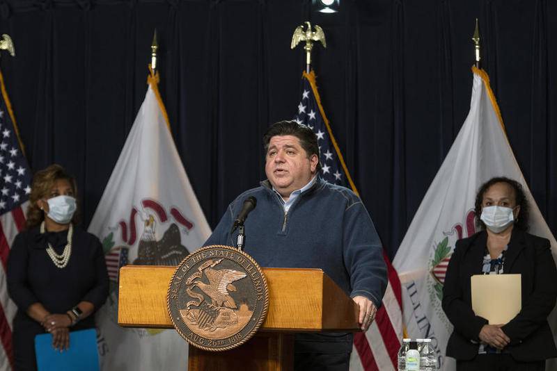Illinois Gov. JB Pritzker, center, along with health and education officials, speaks during his daily coronavirus news conference at the Thompson Center in Chicago, Friday, April 17, 2020.