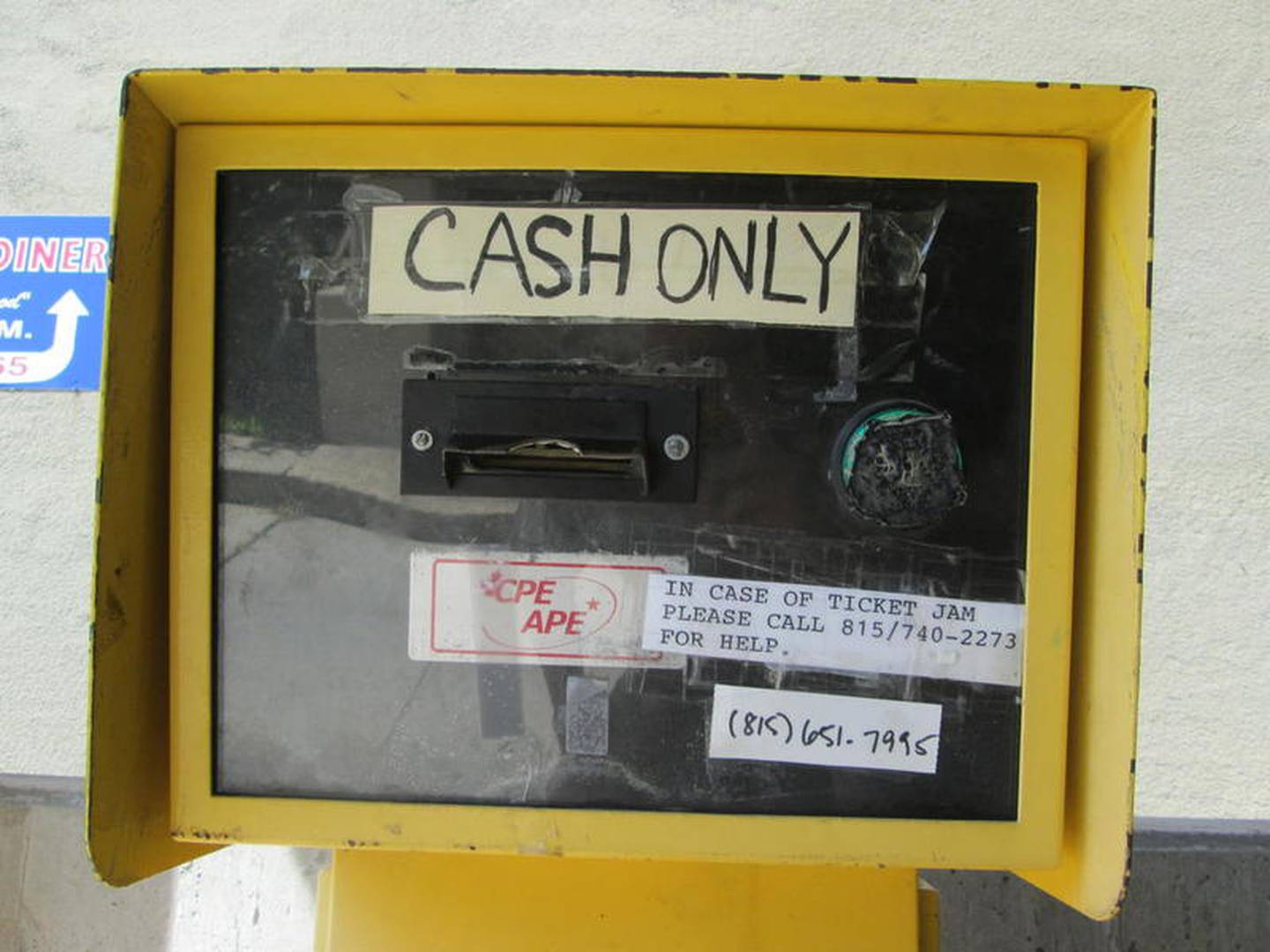 The ticket dispenser warns customers entering the Ottawa Street parking deck that it's a cash-only payment system.