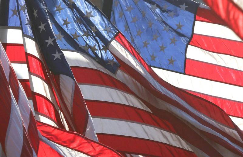 Backlit American flags wave along the Avenue of Flags in front of the DeKalb County Courthouse in Sycamore Friday during the opening ceremony for the 24-hour Veterans Vigil.