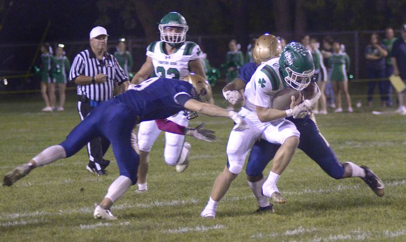Seneca’s Gunner Varland breaks the tackle attempts by Marquette’s Easton Debernardi and Marcus Baker in the 2nd quarter Friday at Marquette.