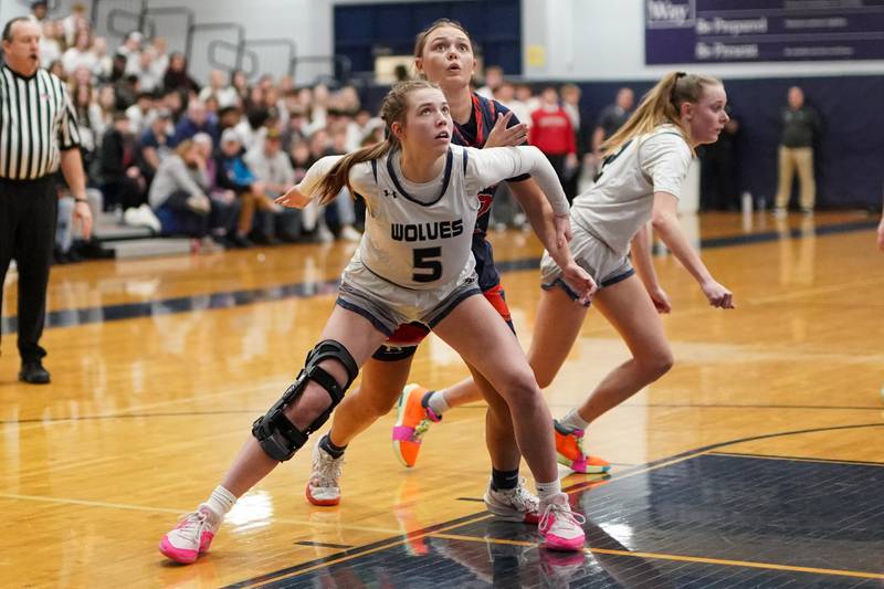 Oswego East's Lillie VanDyke (5) boxes out Oswego’s Kendall Grant (42) during a basketball game at Oswego East High School on Saturday, January 11, 2025.